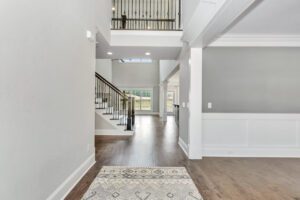 A large open floor plan with a staircase and hallway.