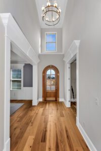 A hallway with a wooden door and white walls.