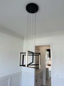 A white room with a black and silver chandelier.